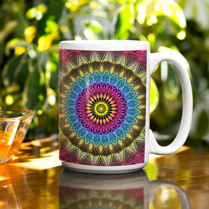 A vibrant mandala mug in pink, blue, and yellow hues, featuring an intricate design that infuses joyful charm into the visual experience
