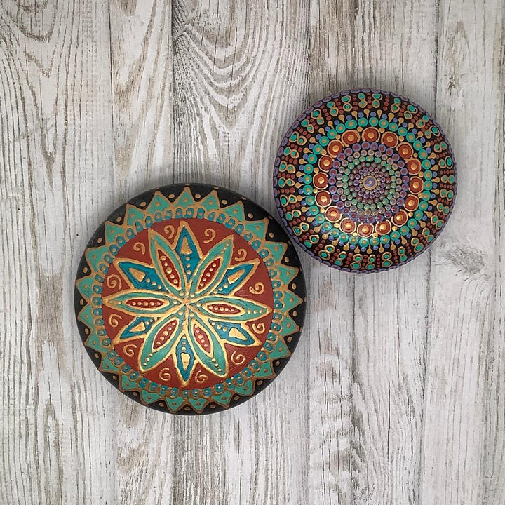 Handgeschilderde mandala steen in turquoise, rood en goud met een zuidelijke uitstraling en glanzende afwerking.
