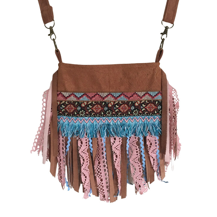 Small bark cloth crossbody bag with pink lace and ribbon fringe, brown plant-based textile, adjustable strap, front view on white background