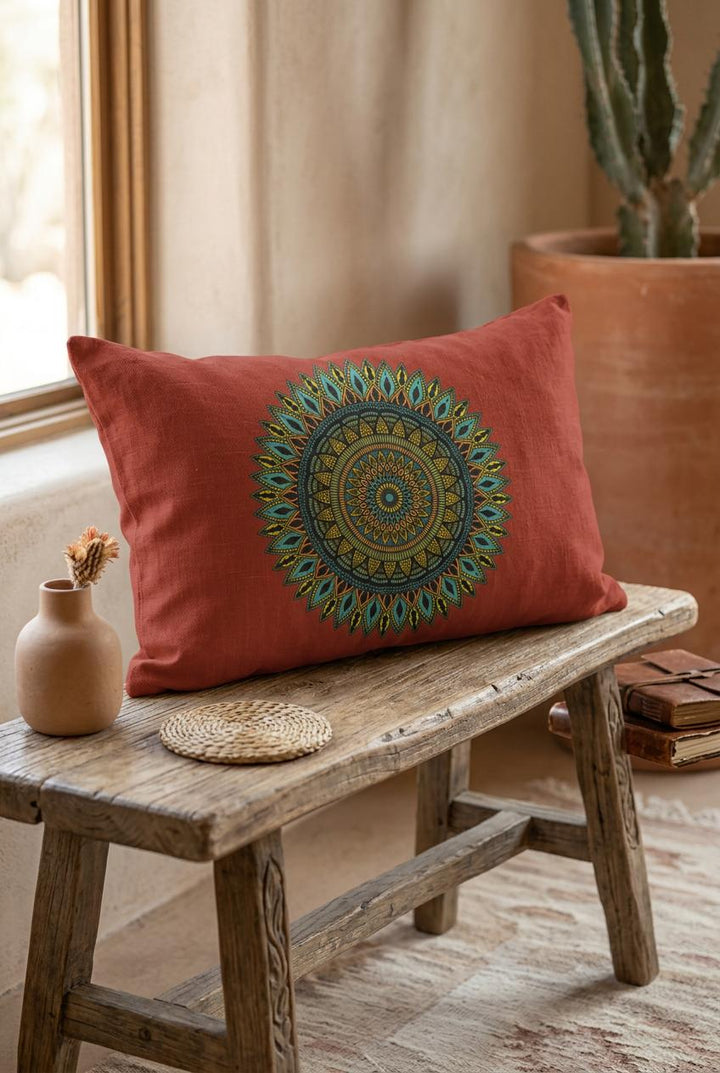 Boho mandala lumbar pillow cover in terracotta with detailed gold and turquoise mandala design on rustic wooden bench in warm boho interior