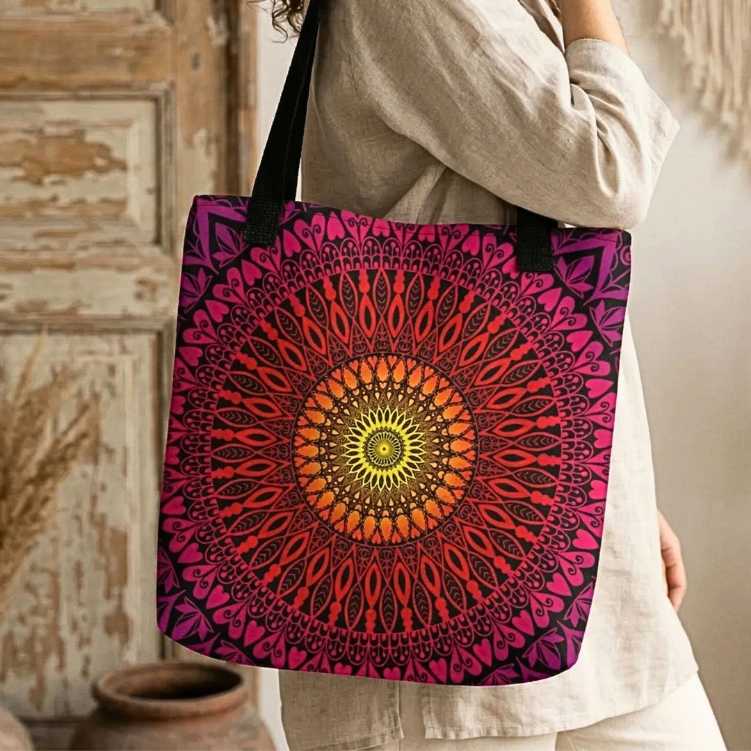close up of bohemian tote bag with vibrant red pink and orange mandala pattern on black background