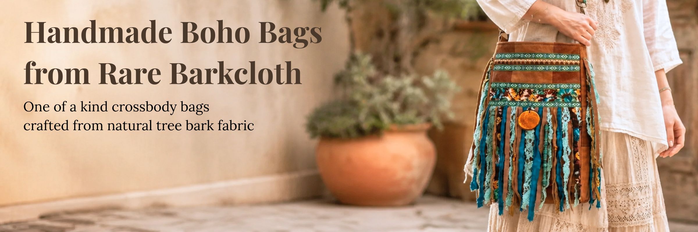 Handmade boho crossbody bag crafted from natural barkcloth, with colorful fringe and patterned details, worn with a cream bohemian dress in a warm earthy setting.