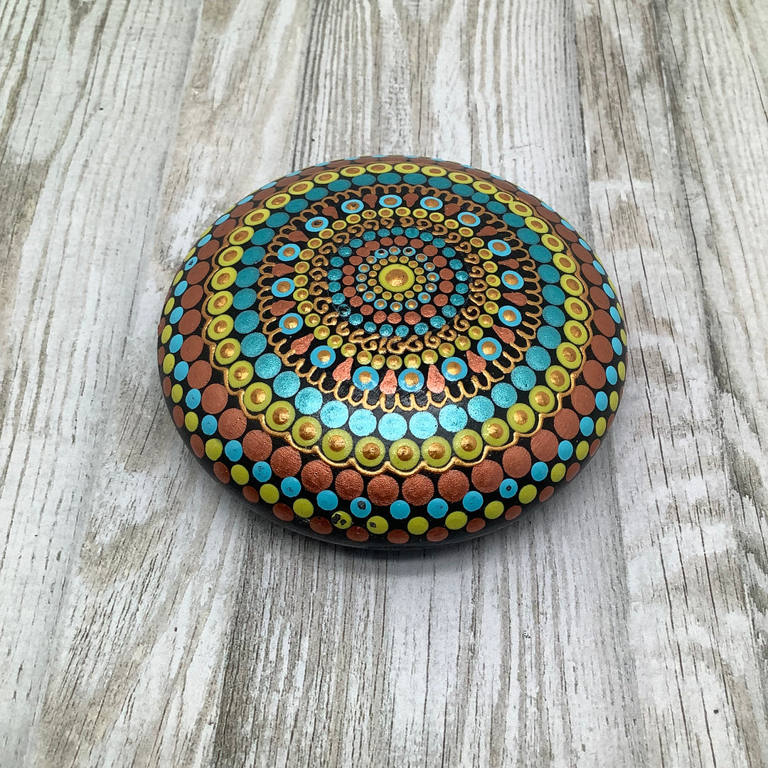 Handbeschilderde mandalasteen in koper, turquoise en geel met goudaccenten, decoratieve kunststeen voor meditatie en huisdecoratie.