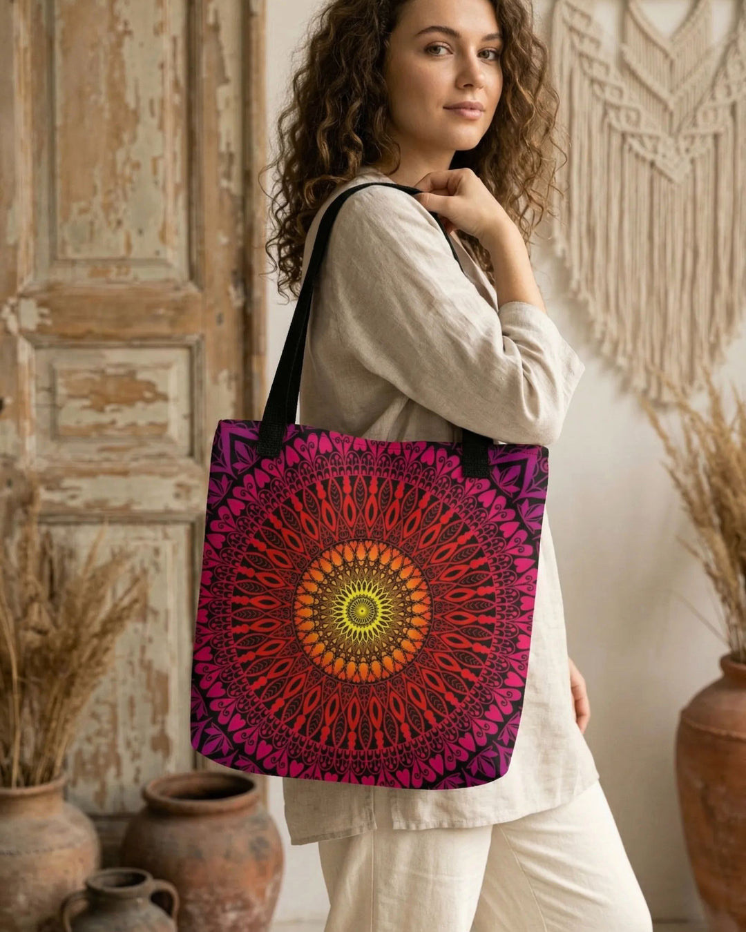 bohemian tote bag with bold mandala design in red pink and orange worn by woman in soft natural outfit