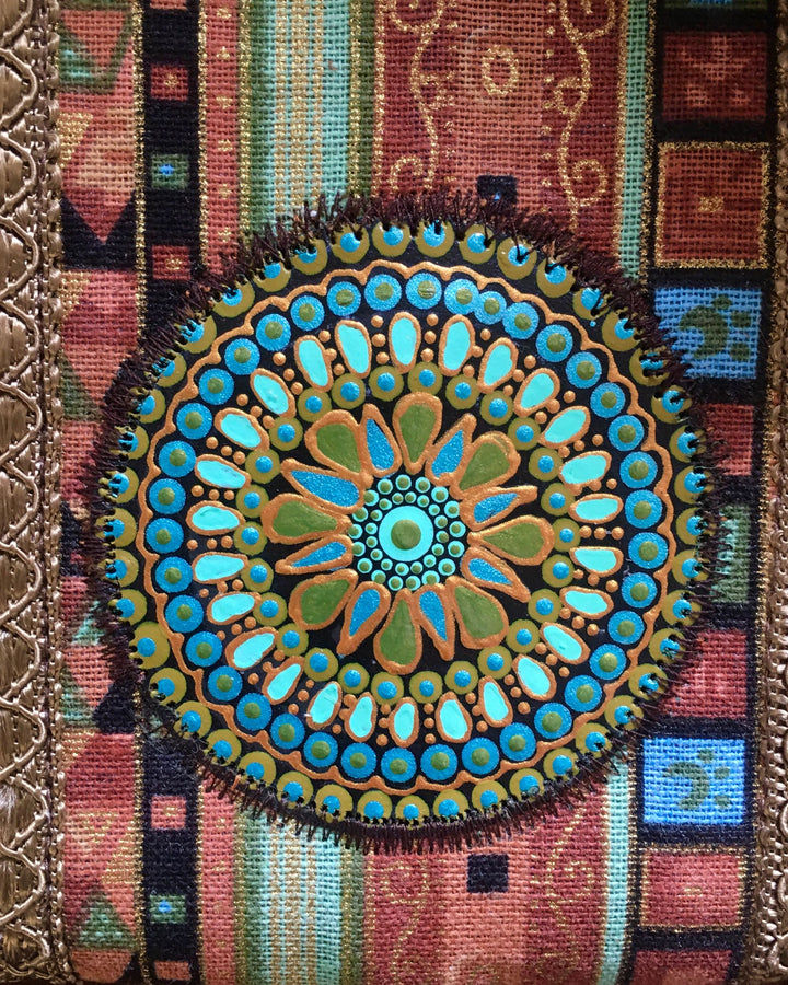 Decorative mandala with blue and green colors on a textured background