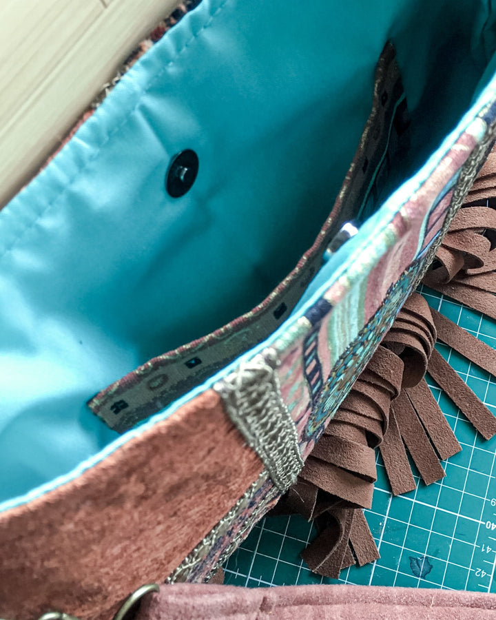 Close-up of a fabric item with fringe on a cutting mat