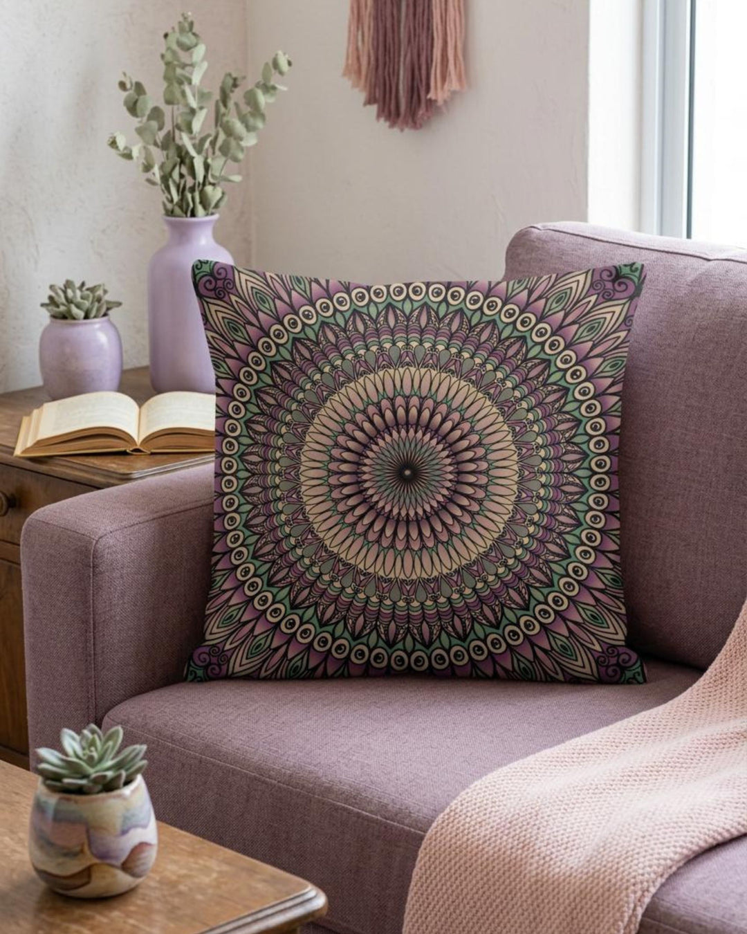 Decorative pillow with mandala pattern on a purple couch in a living room setting.