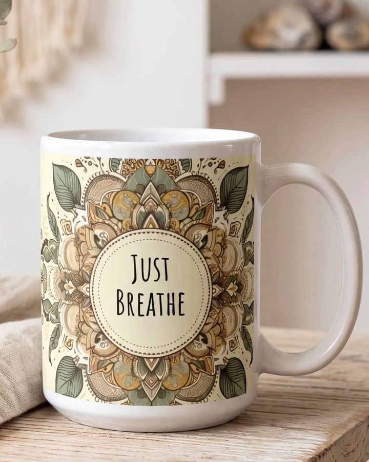 White ceramic boho mug with green mandala and Just Breathe quote styled on a rustic wooden table in a warm bohemian home interior with natural light
