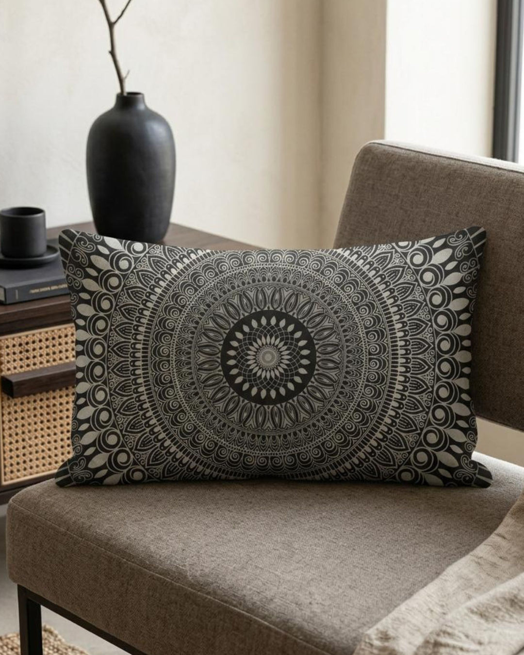 Boho lumbar pillow cover in black, white and grey mandala design styled on a taupe chair in a sophisticated modern boho interior