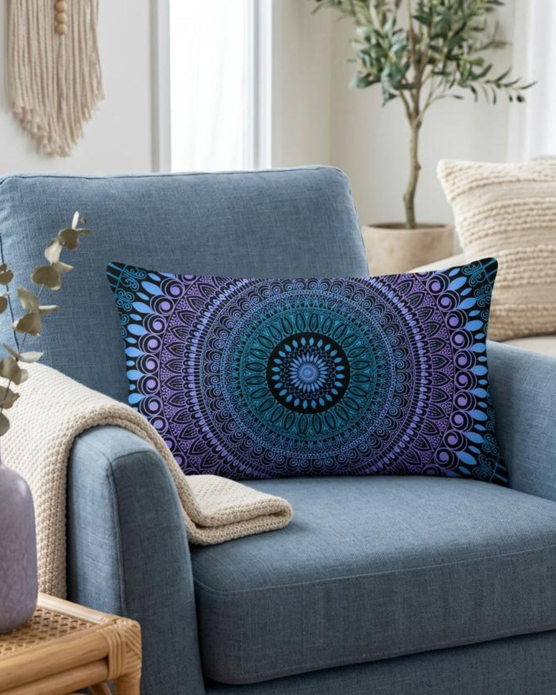 Boho lumbar pillow cover in blue, lavender and black mandala design styled on a dusty blue armchair in a calm boho interior