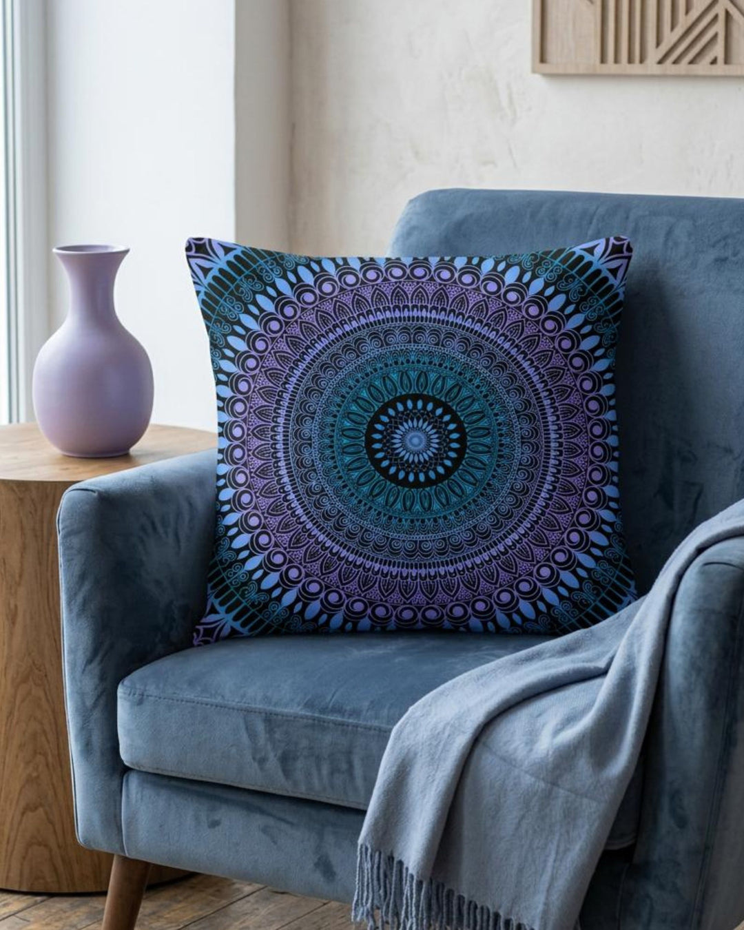 Boho square pillow cover in blue, lavender and black mandala design styled on a rich dusty blue armchair in a calm boho interior