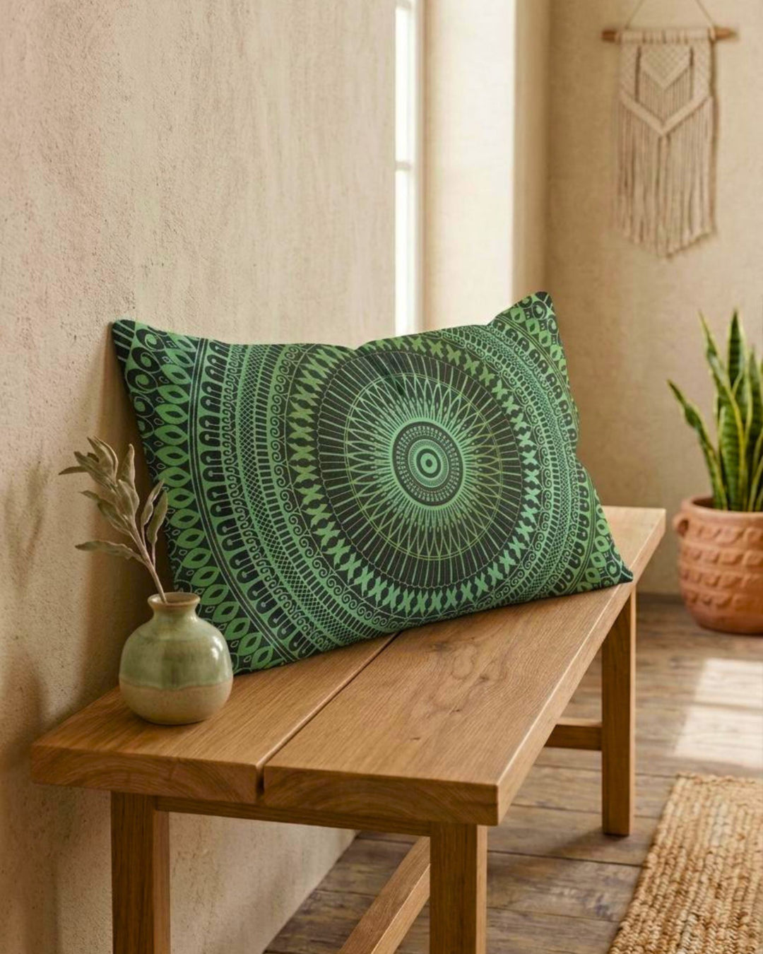 Green mandala lumbar pillow cover on a wooden bench, softly angled forward in a calm boho interior with textured beige wall, ceramic vase and plant, natural daylight and earthy tones