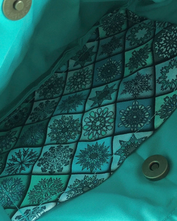 Close-up of teal fabric with a geometric pattern