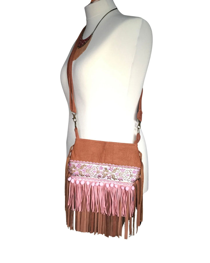 Brown fringe bag with pink accents on a mannequin against a white background