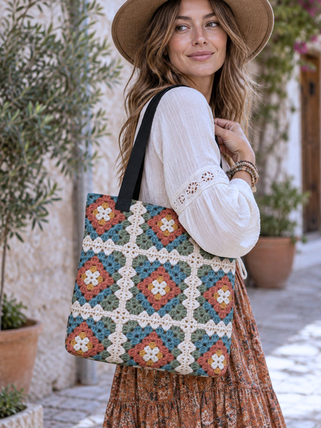 Granny square printed tote bag with black handles styled in a warm boho lifestyle setting