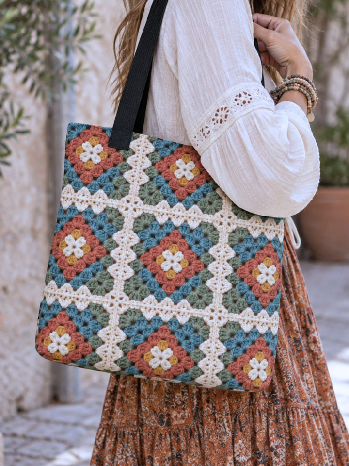 Boho woman carrying a printed granny square tote bag with black handles in teal, rust, sage, cream and mustard