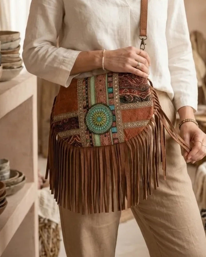 Person holding a colorful fringed handbag in a casual setting