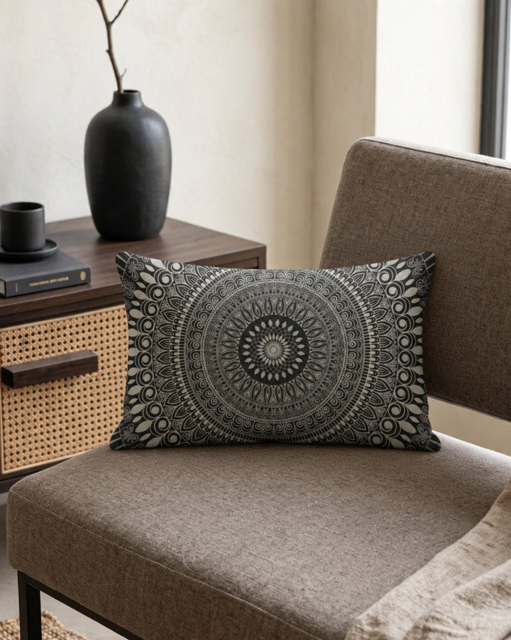 Boho lumbar pillow cover in black, white and grey mandala design styled on a taupe chair in a sophisticated modern boho interior