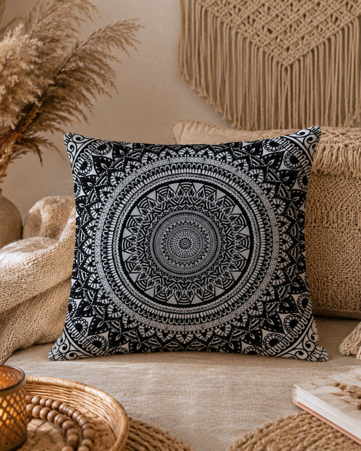 black and white mandala throw pillow on beige sofa in cozy boho living room with macrame wall hanging pampas grass and warm natural textures