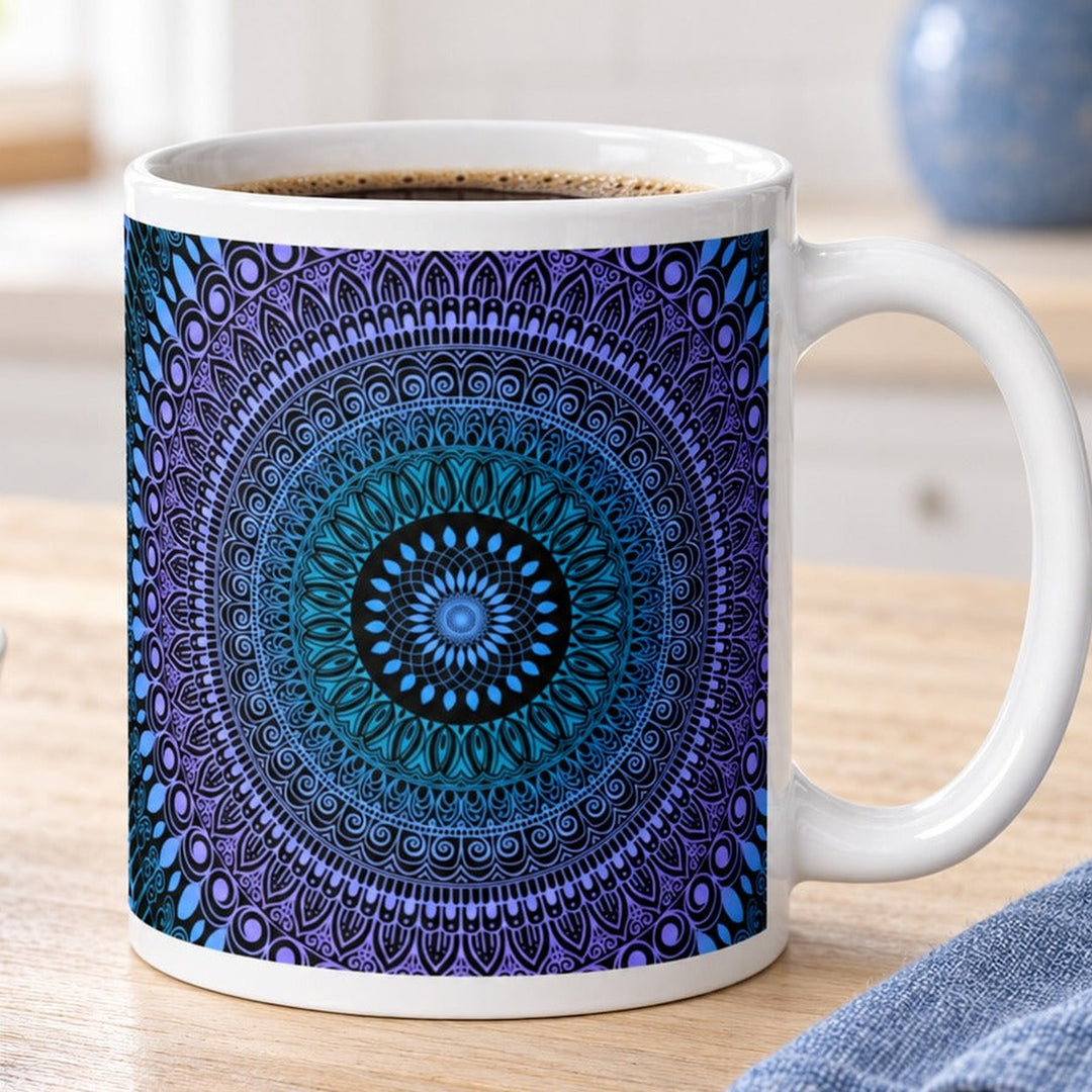 Close-up lifestyle photo of white ceramic mug with blue turquoise and lavender mehndi mandala.