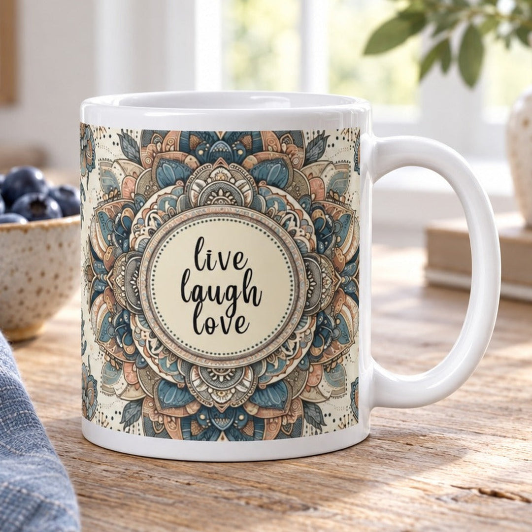 Close-up lifestyle photo of white ceramic Live Laugh Love mug with blue mandala design.