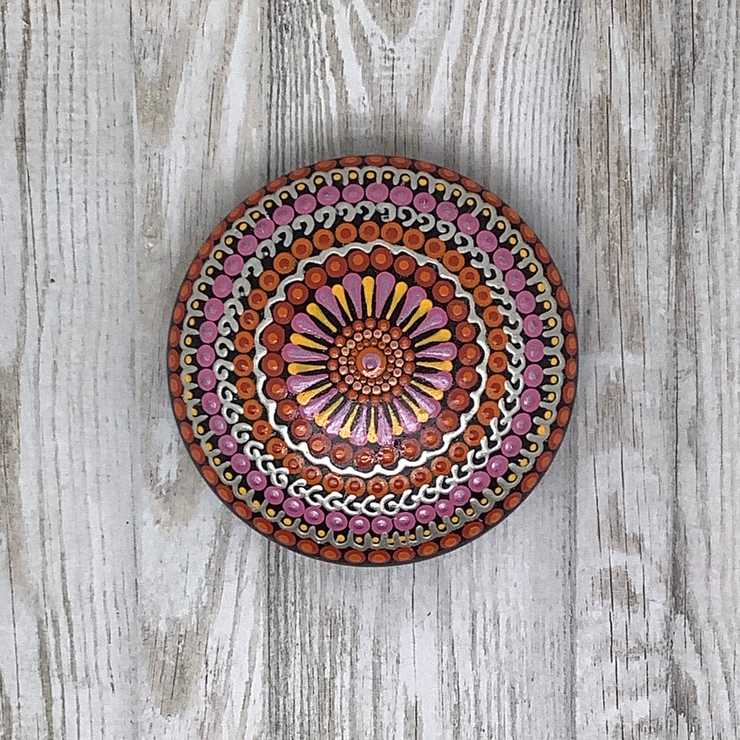 painted mandala rock in pink orange and silver