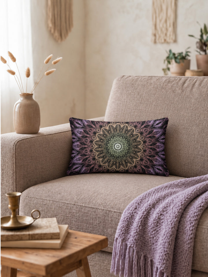 Bohemian lumbar cushion cover with mandala pattern in black, purple and green tones on pastel mauve sofa in warm cozy interior