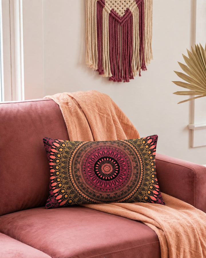Boho lumbar pillow cover in pink, coral, gold and black mandala design styled on a dusty rose sofa in a warm colorful boho interior