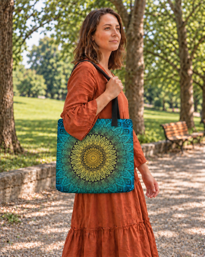 Woman carrying a green blue and yellow mandala tote bag in a park