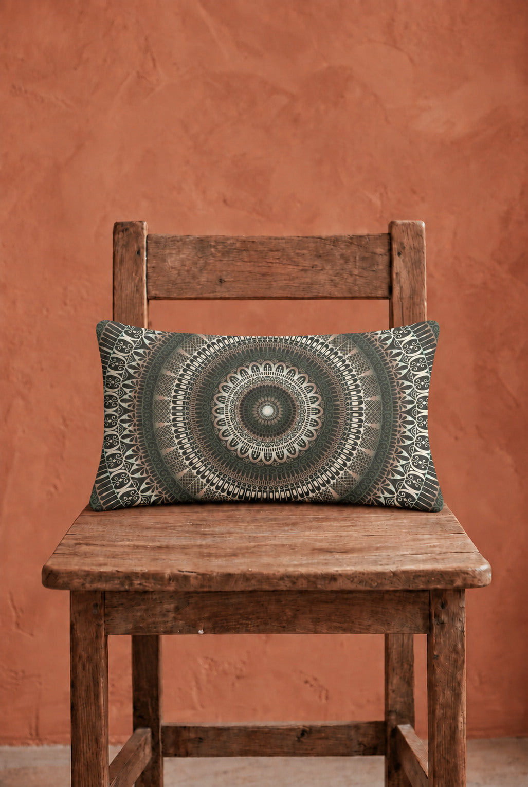 Boho lumbar pillow 12x20 inch with green mandala design on rustic wooden chair, warm terracotta wall, matte linen look fabric, natural woven texture, soft daylight interior