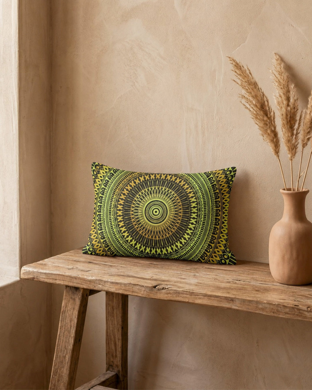 Boho lumbar pillow cover with green and yellow mandala design on a rustic wooden bench, styled with a ceramic vase and dried pampas grass, warm natural light and textured beige wall, premium linen-look fabric