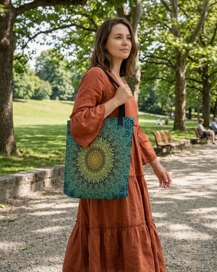bohemian woman walking in a park carrying a green mandala tote bag with detailed pattern in natural daylight