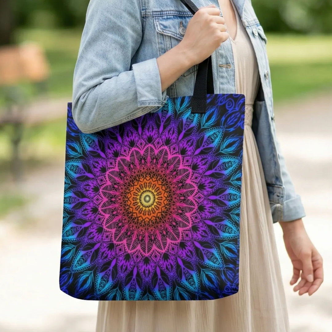Boho tote bag met kleurrijke mandala print in paars blauw en oranje gedragen door vrouw met lichte jurk en denim jasje in park