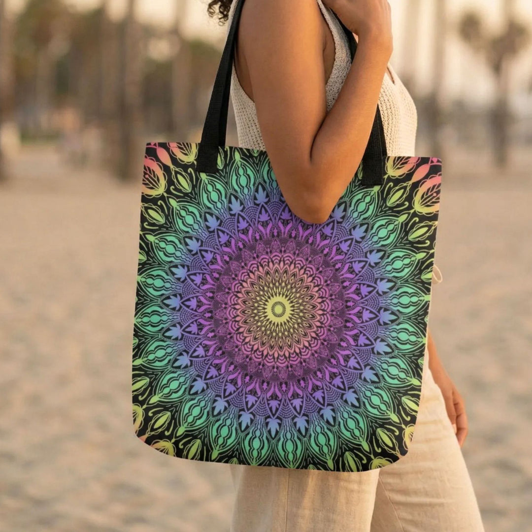 Close-up of a colorful mandala tote bag showing detailed pattern and vibrant colors, worn on the shoulder, soft natural light, blurred beach background, focus on texture and design