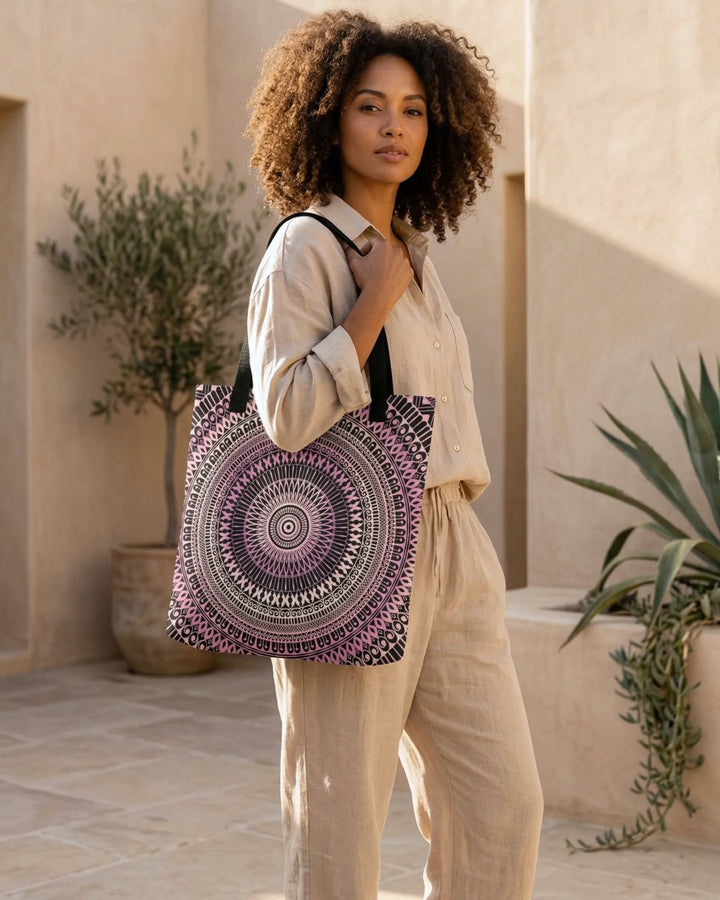 boho tote bag with pink mandala design worn by woman with curly hair, beige linen outfit, warm sunlight, minimalist earthy background, stylish everyday bag