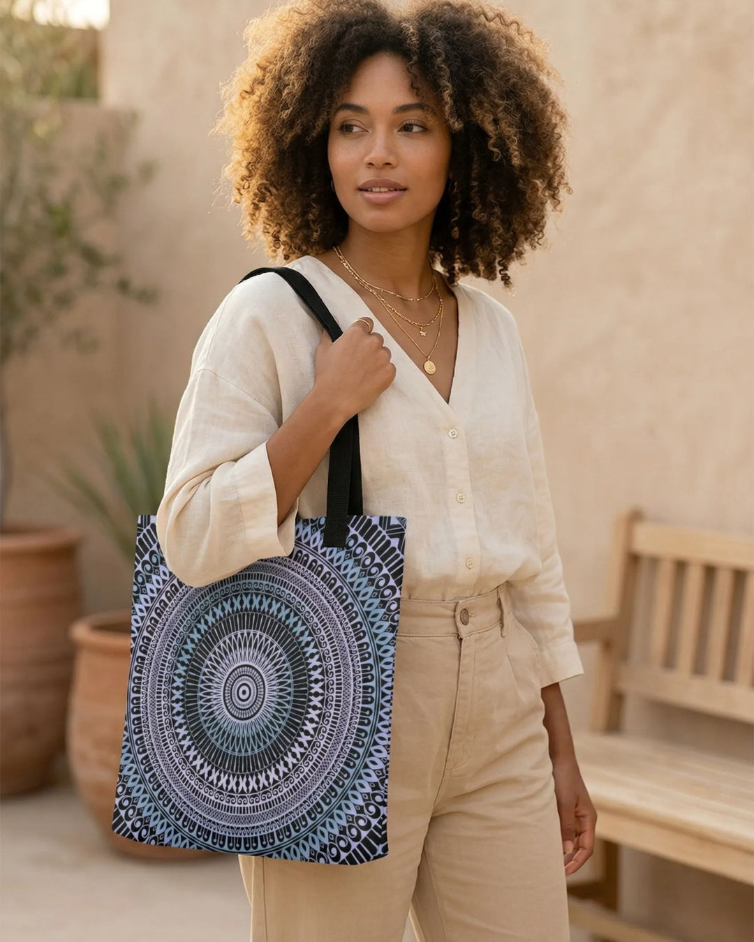 black and white mandala tote bag worn by woman in neutral linen outfit, elegant boho style outdoor setting soft natural ligh