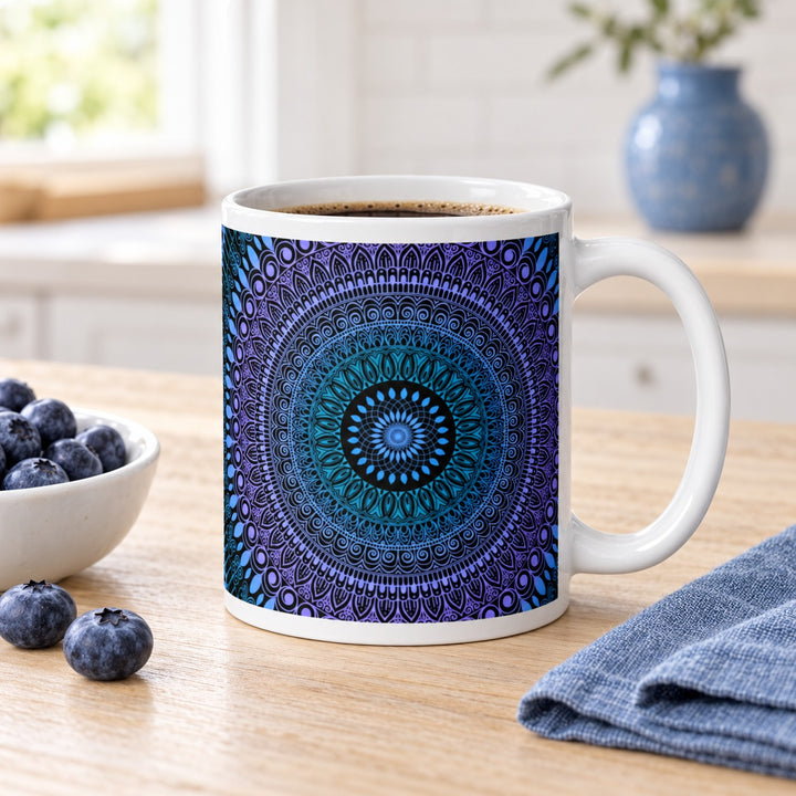 11 oz white ceramic mug with blue, turquoise and lavender mehndi mandala on a breakfast table beside blueberries.