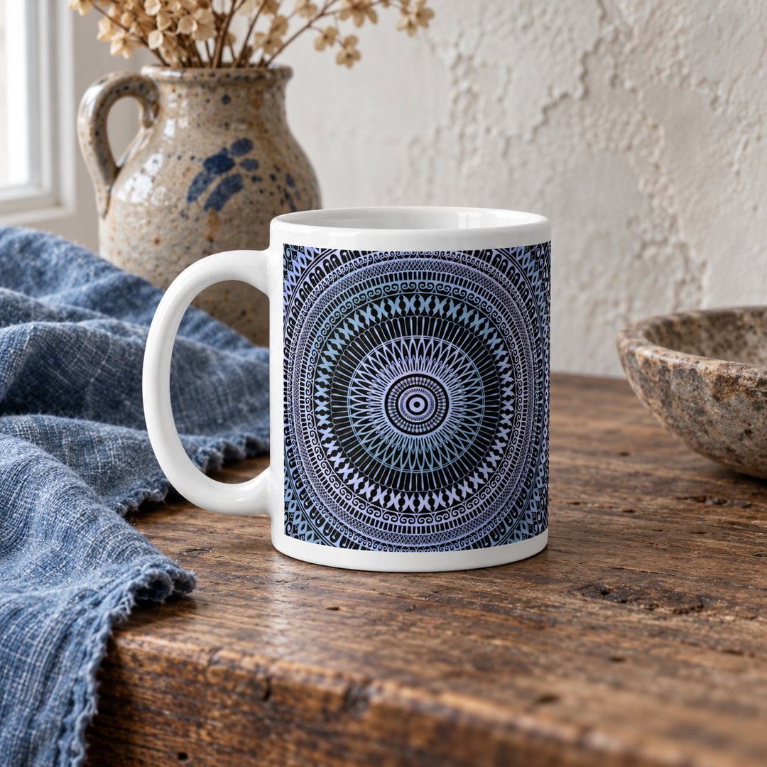 11 oz pale blue and soft pink mandala mug styled on a rustic vintage wooden table