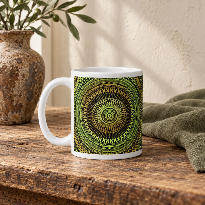 11 oz soft green and ochre mandala mug styled on a rustic vintage wooden table