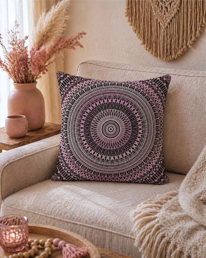 Bohemian square throw pillow with mandala design in blush pink and black tones on beige linen sofa in warm neutral interior