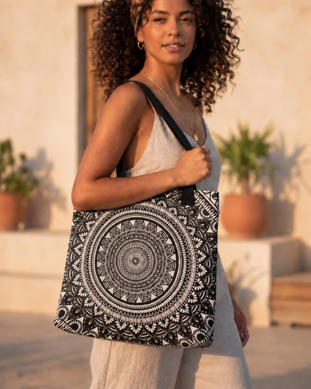 White and black mandala tote bag worn by a woman in a boho outfit