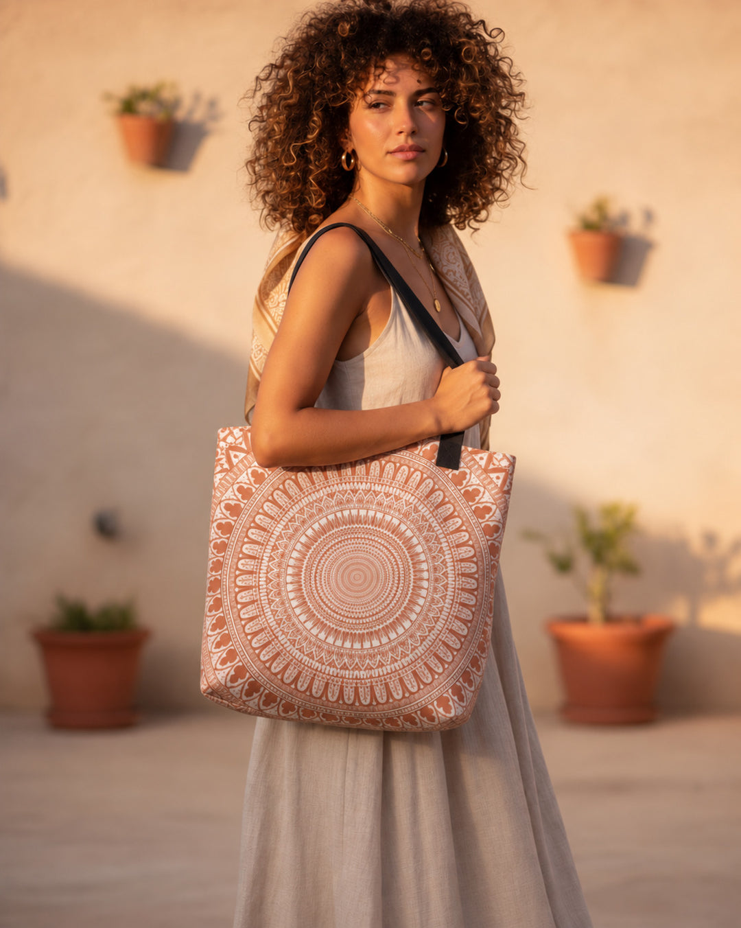 White and terracotta mandala tote bag carried by a woman in a neutral boho outfit